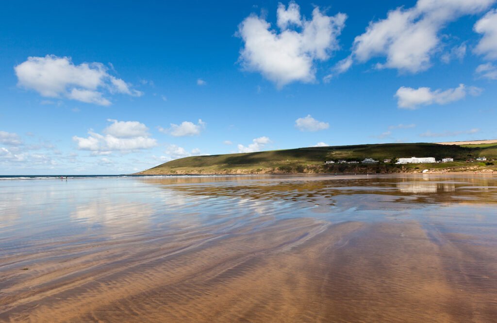 image of the beach at Taunton sands - golden sands and a low tide with the cliffs in the background